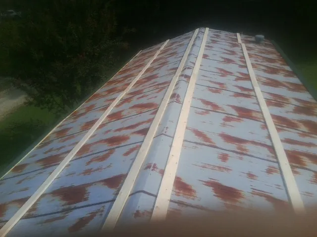 Rusted metal roof panels with new wood purlins before replacement — Storm Damage Roof Repair in Natick by Roofing Brothers