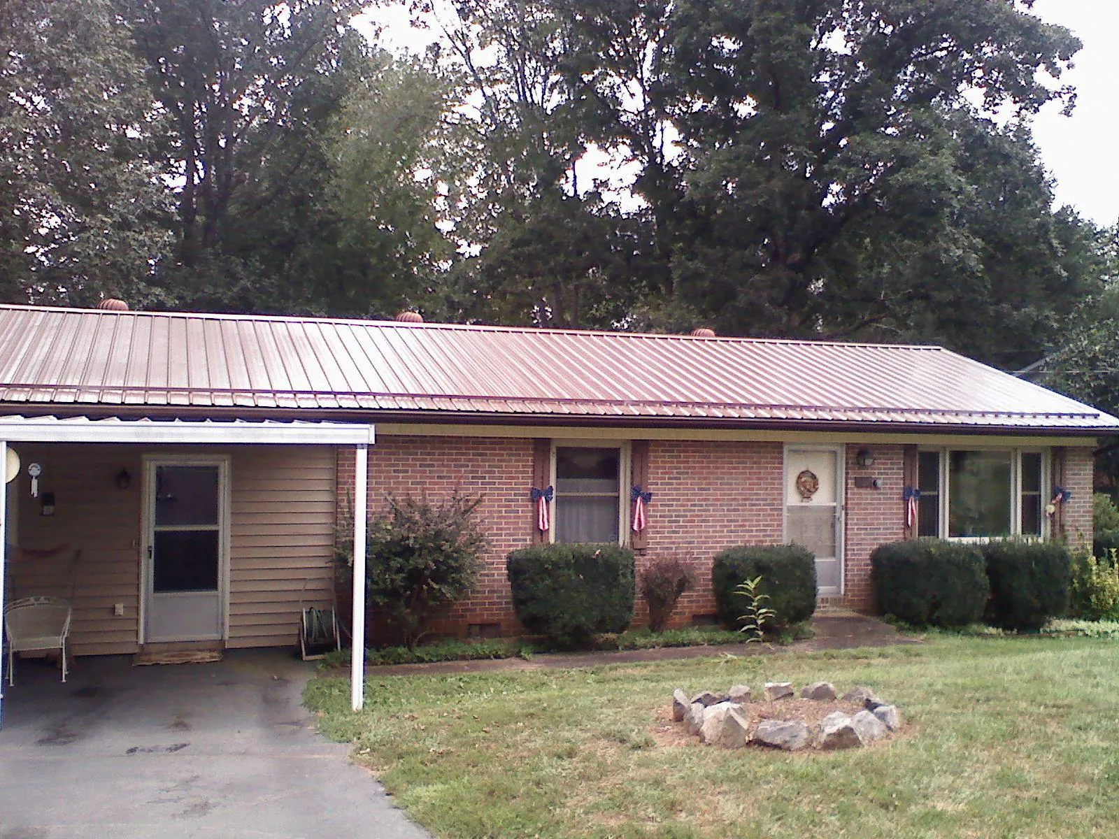 Bronze metal roof and carport on a brick ranch home — Roof Repair work by our crew in Natick